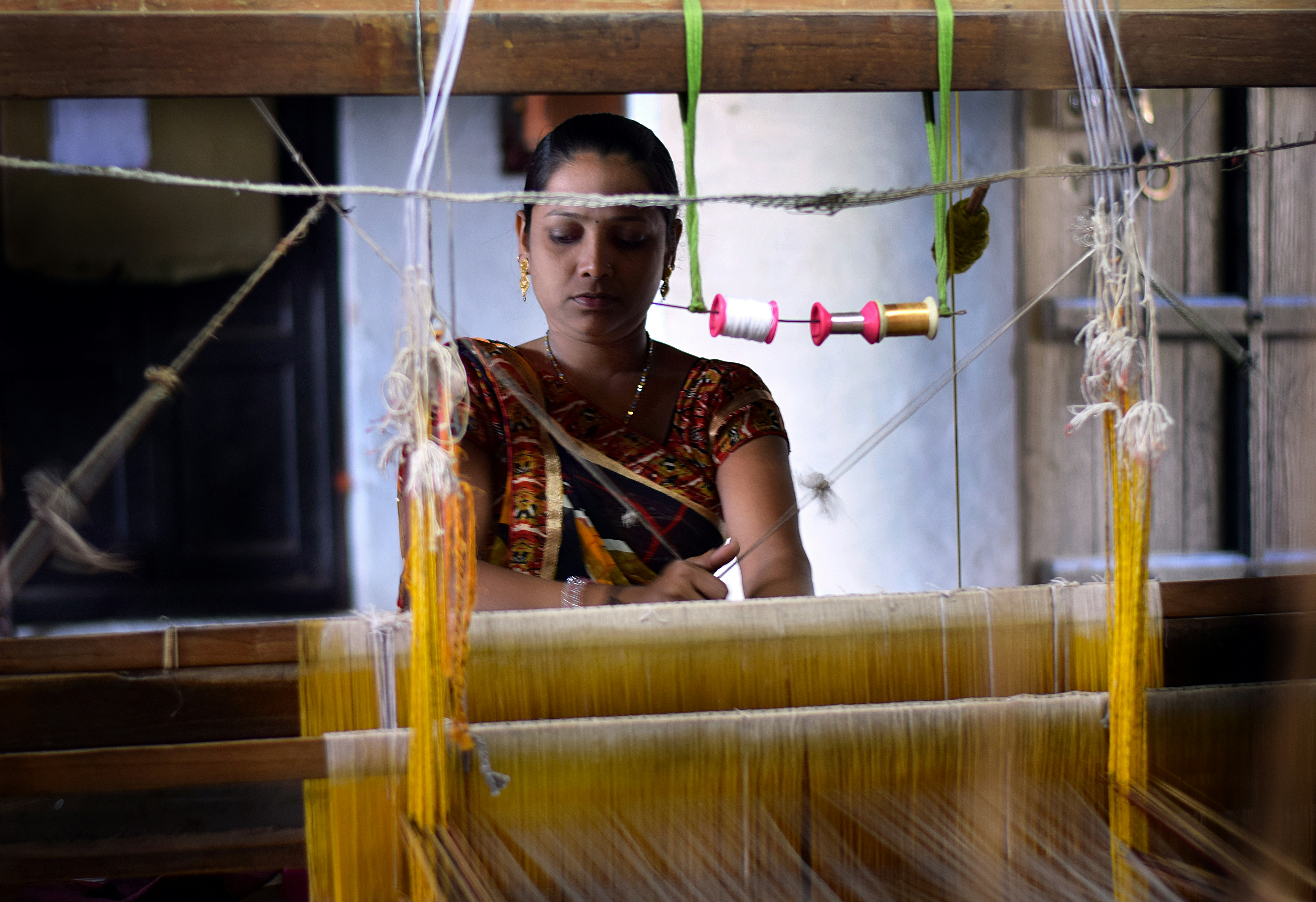 Woman weaving on a loom in a workshop